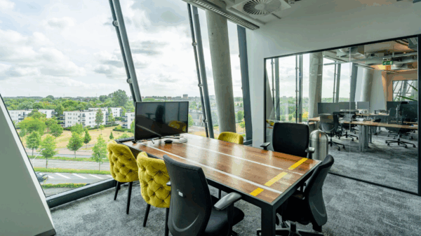 Modern meeting room at TT Vasumweg with large windows overlooking a green residential area.