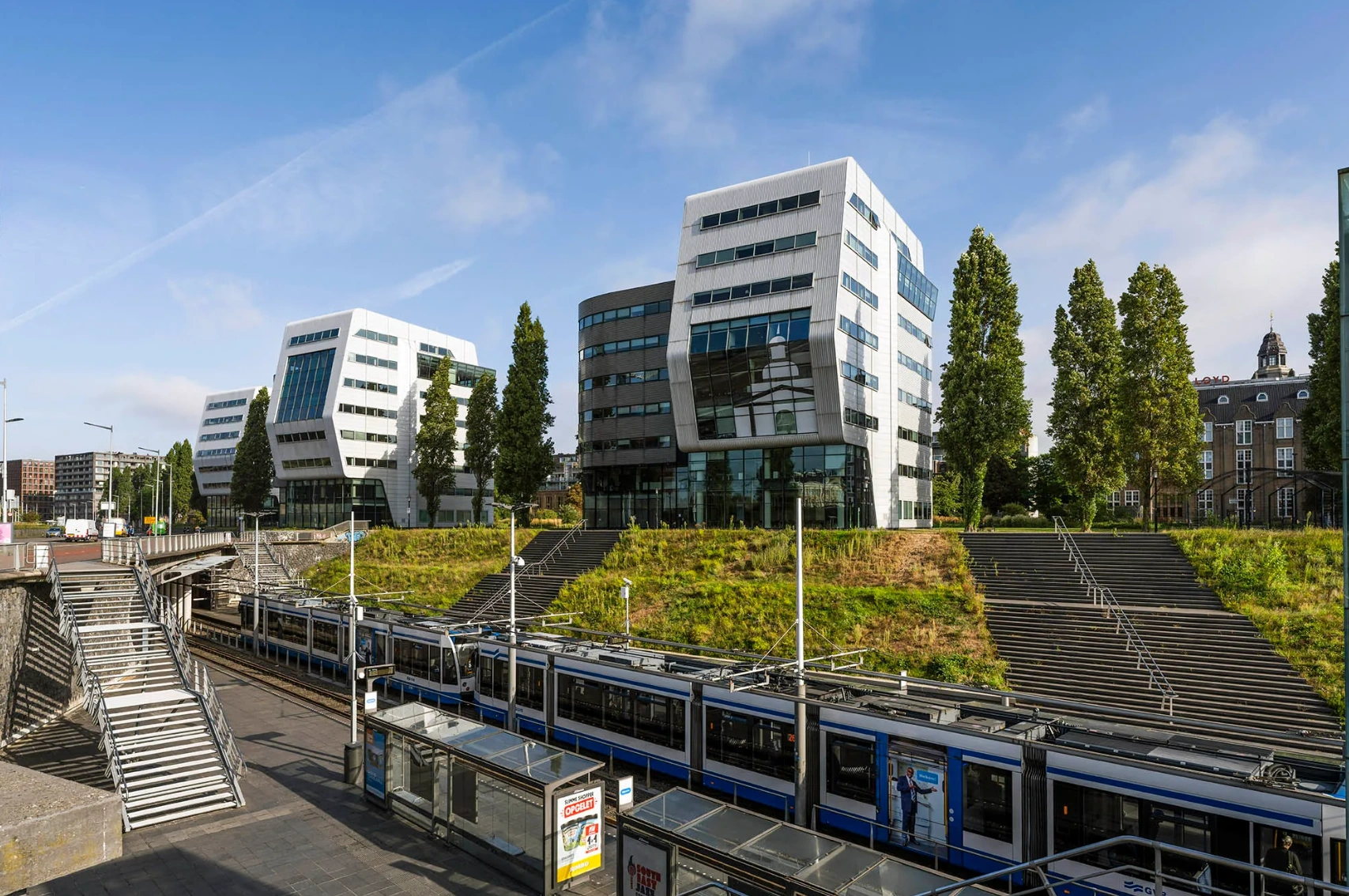Modern office buildings at Rietlandpark in Amsterdam with a tram station in the foreground.