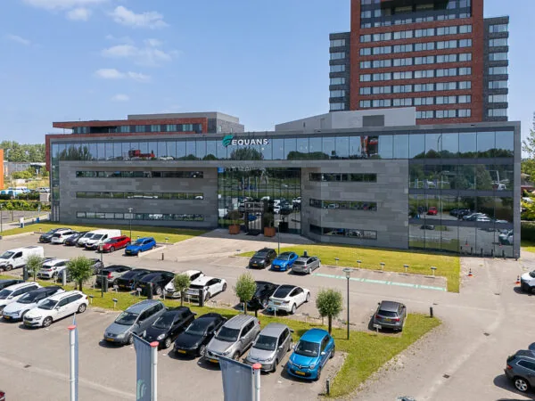 Modern office building of Equans on Laan van Barcelona with a parking lot in front.