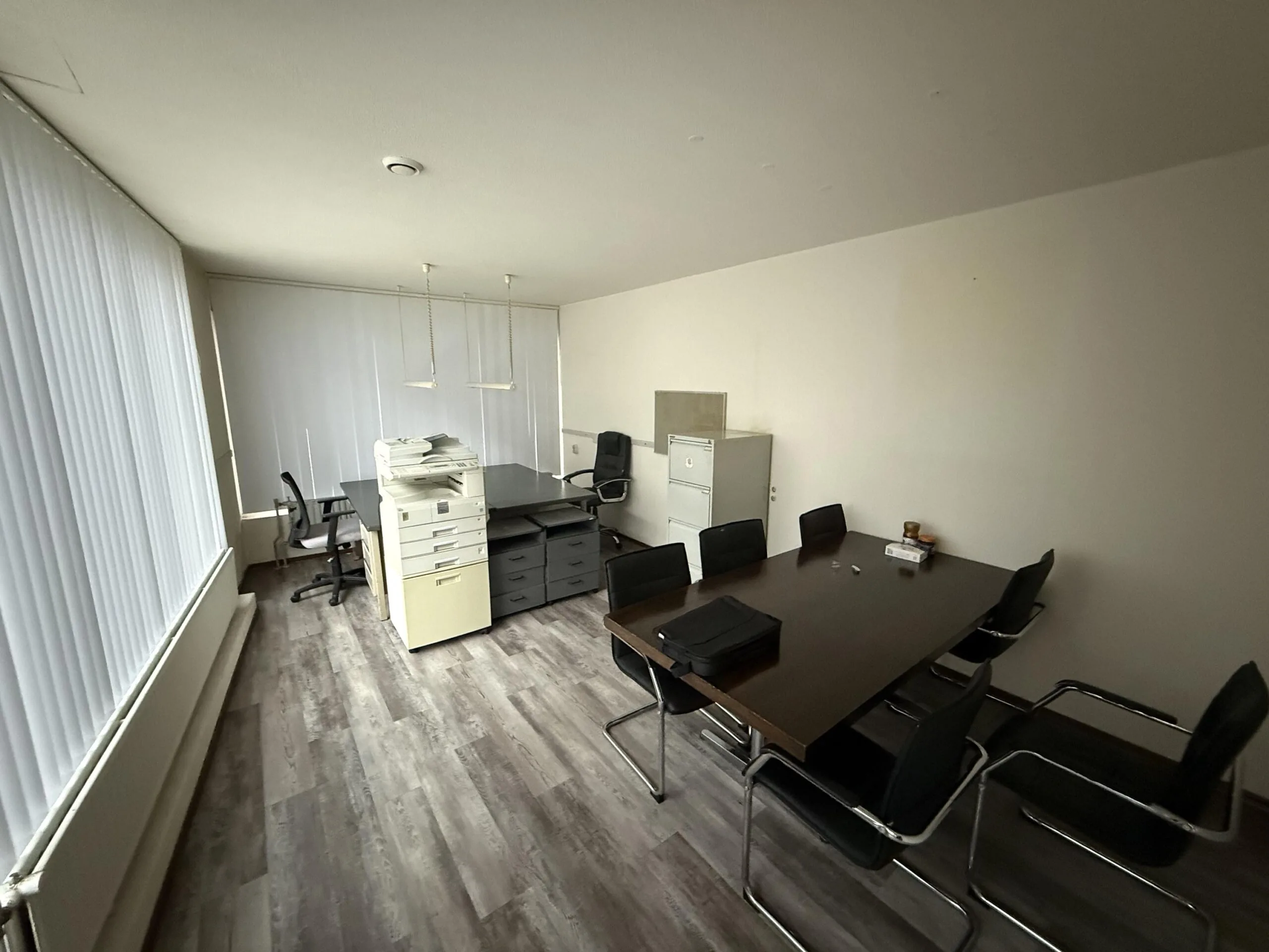 Modern office space on Katendrechtse Lagedijk with a conference table, filing cabinets, and workstations.