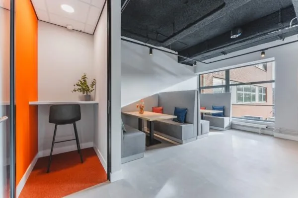 Modern office seating area at Paasheuvelweg with private booths and a small work nook.