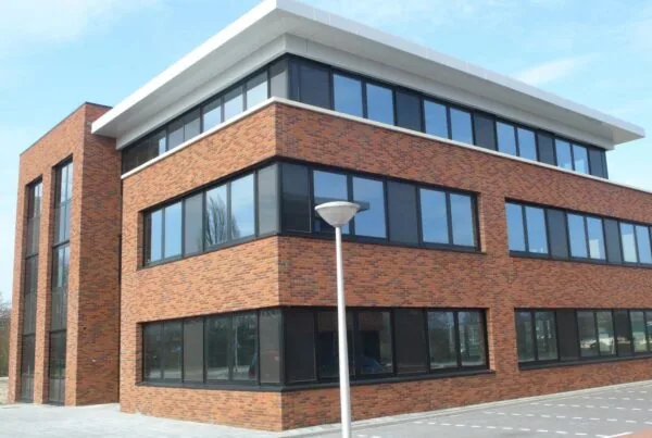 Modern three-story office building with red brick facade located on Veteranenlaan.
