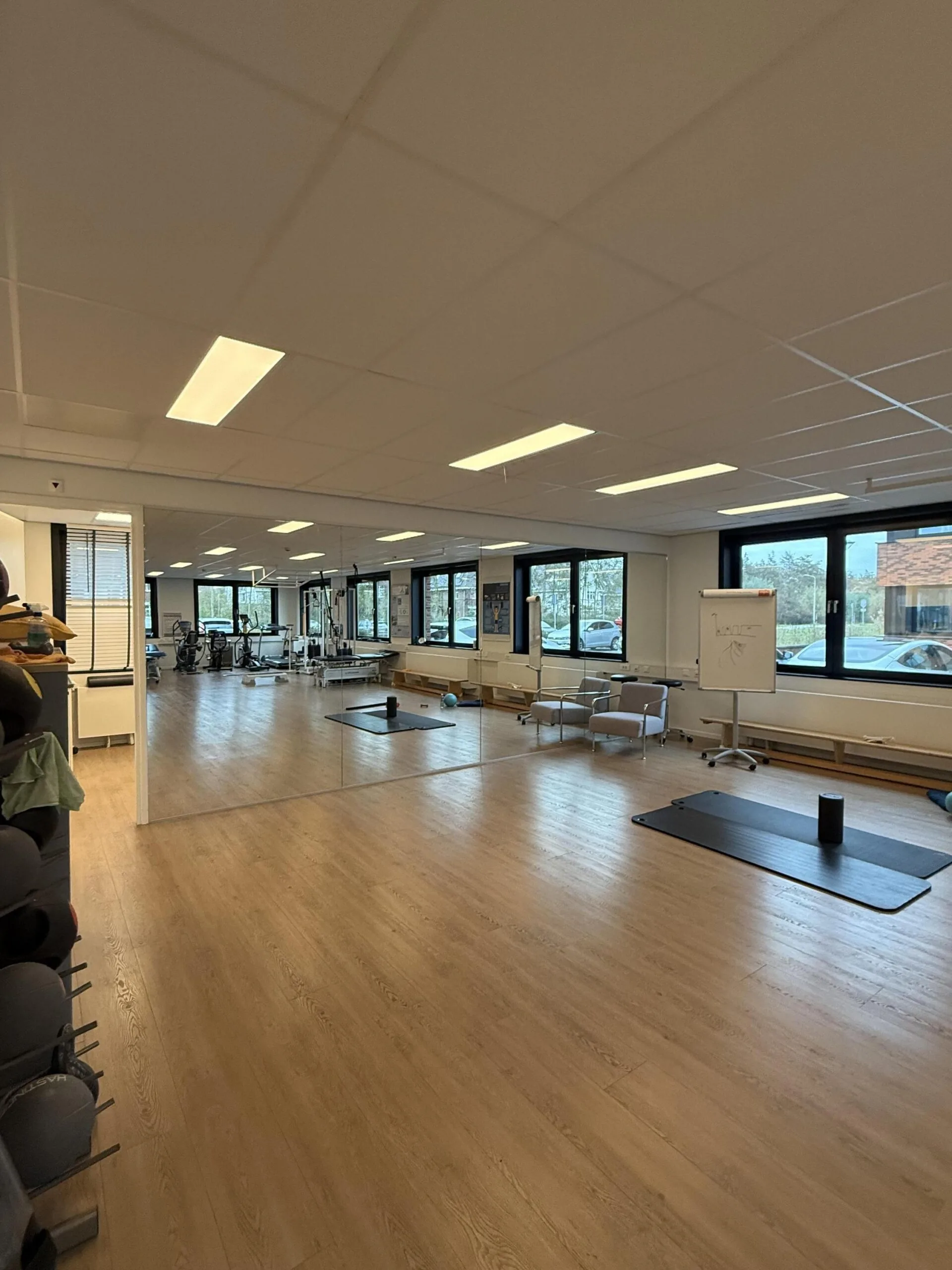Spacious physical therapy or fitness room at Veteranenlaan, with exercise mats, gym equipment, and large mirrors.
