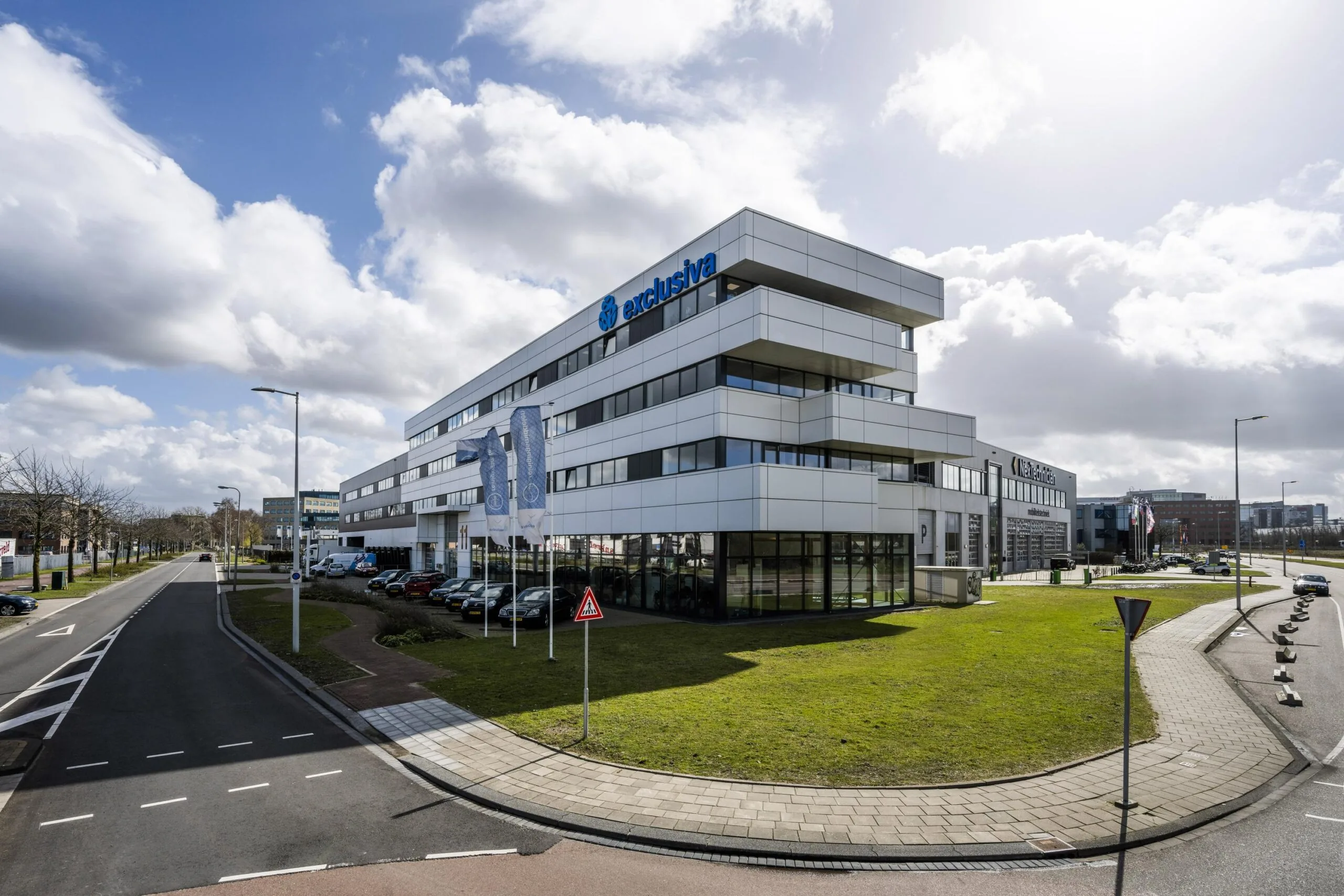 Modern office building of Exclusiva on Dynamostraat with adjacent parking and surrounding road infrastructure.
