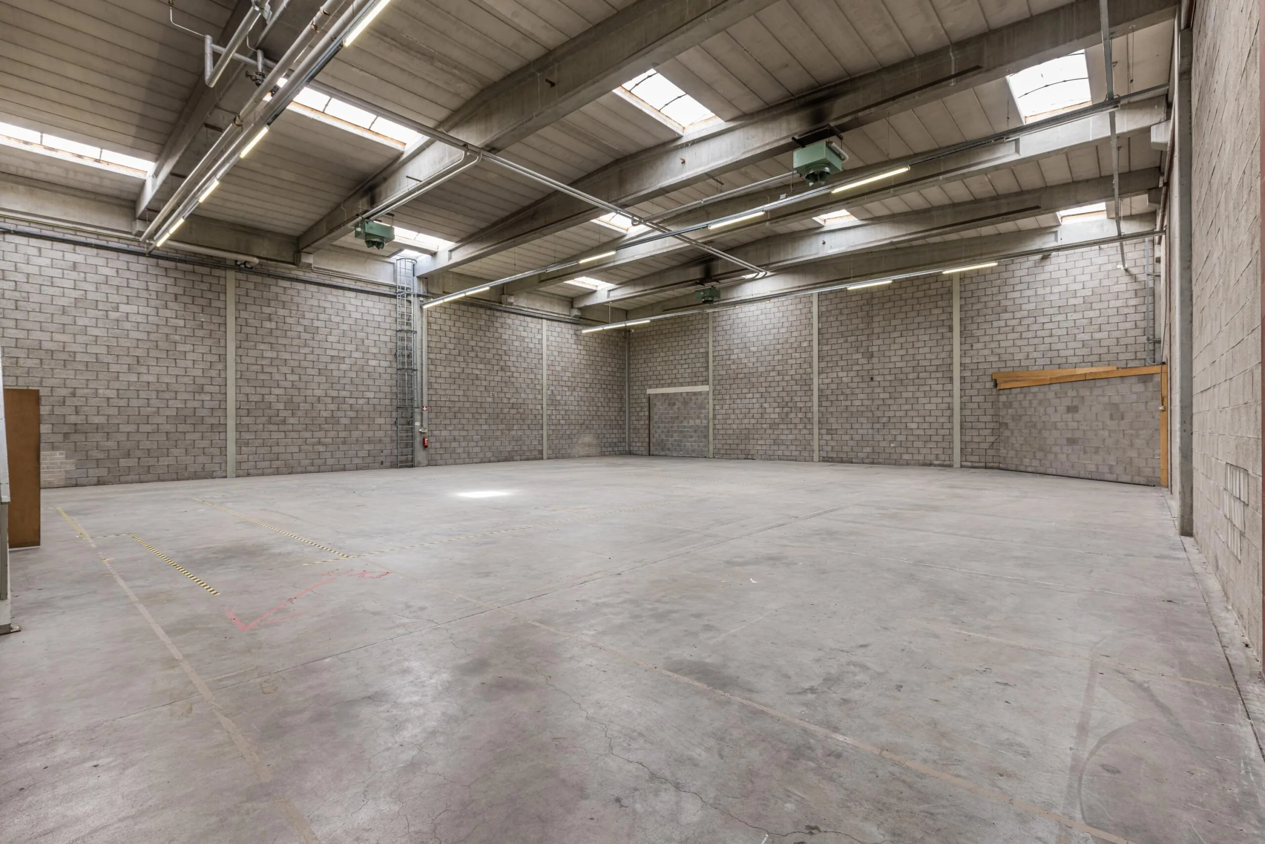Spacious empty warehouse with concrete floors and high ceilings located on Zonnebaan.