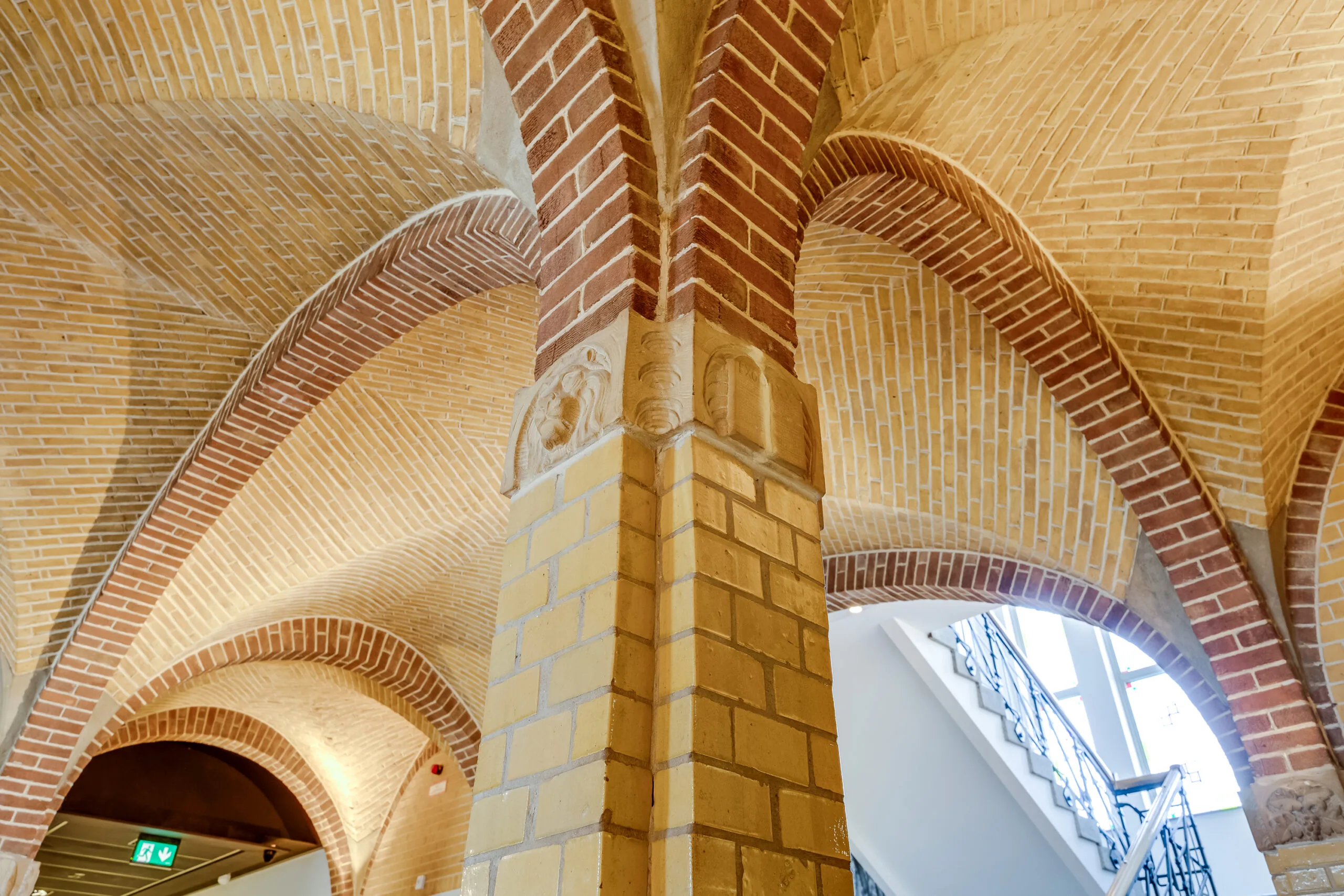 Vaulted brick ceiling with decorative column details in the interior of a historic building on Lage Naarderweg.