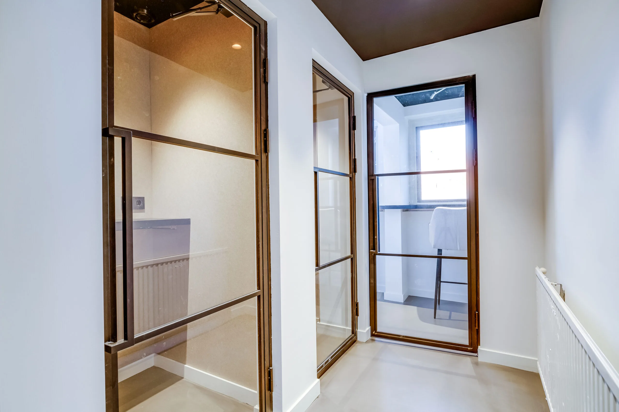 Modern hallway with glass and steel interior doors in a property on Lage Naarderweg.