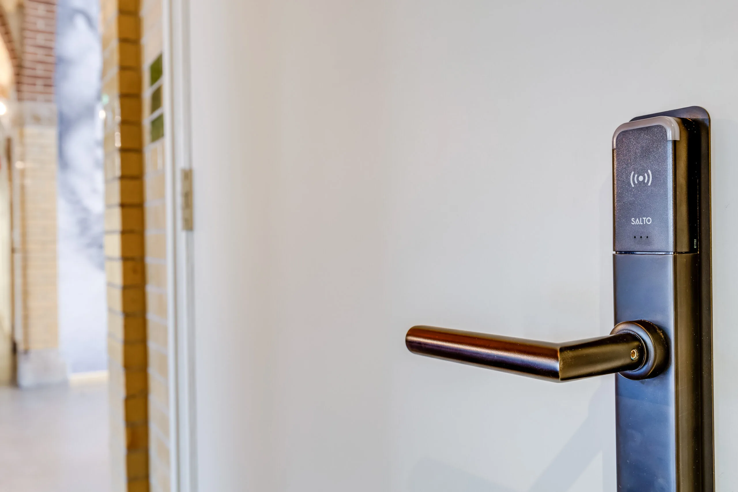 Close-up of a modern electronic door handle with a SALTO access control system on Lage Naarderweg.