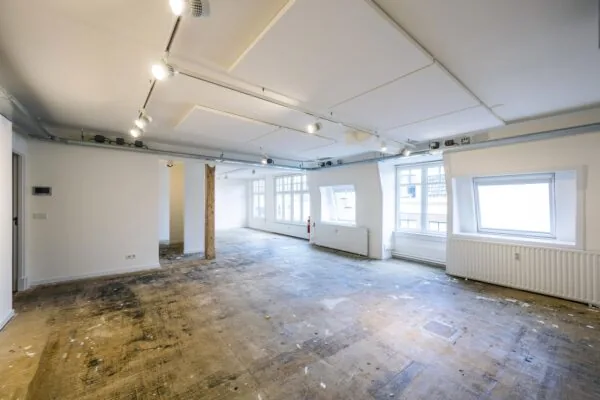 Licht en ruim leegstaand interieur met grote ramen aan de Nieuwe Spiegelstraat.