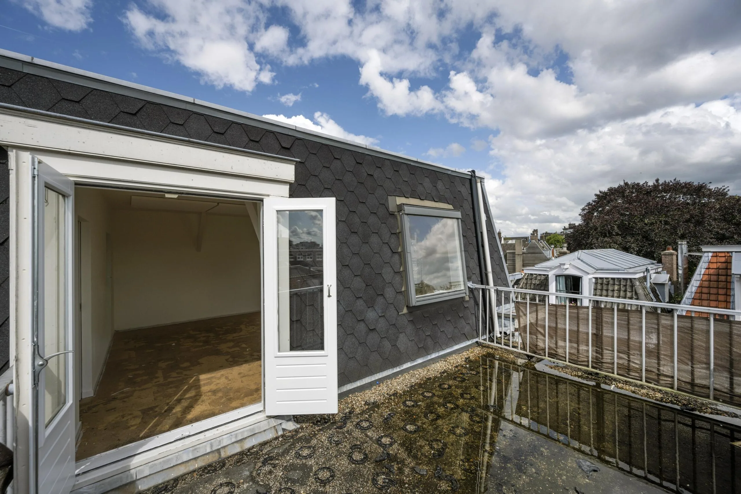 Dakterras met openslaande deuren en uitzicht op de Nieuwe Spiegelstraat in Amsterdam.