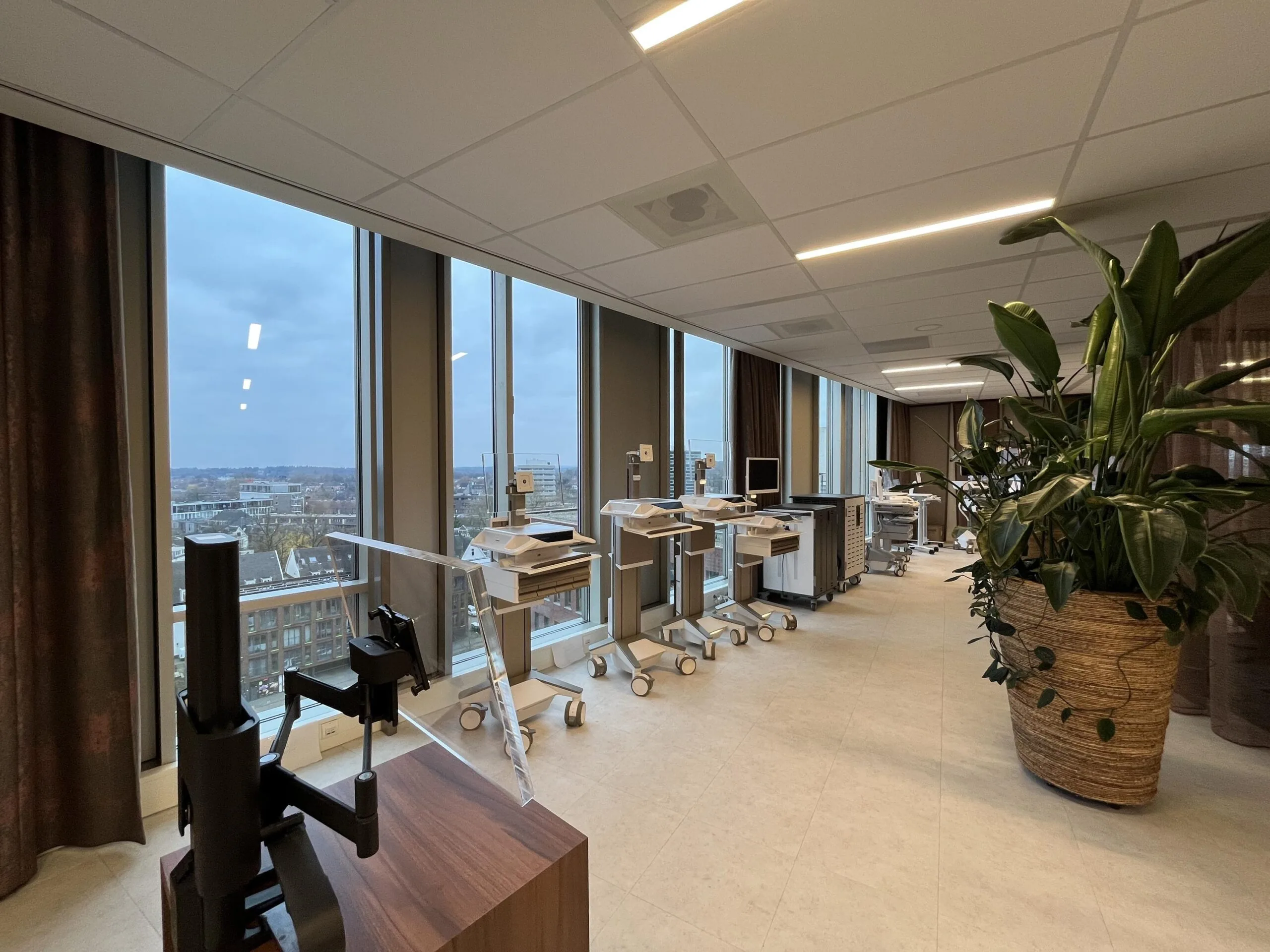 Moderne ziekenhuisafdeling met medische apparatuur, grote ramen en uitzicht over de stad.