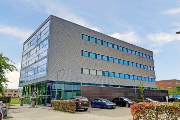 Modern kantoorgebouw aan de New Yorkstraat met glazen gevel en geparkeerde auto's ervoor.