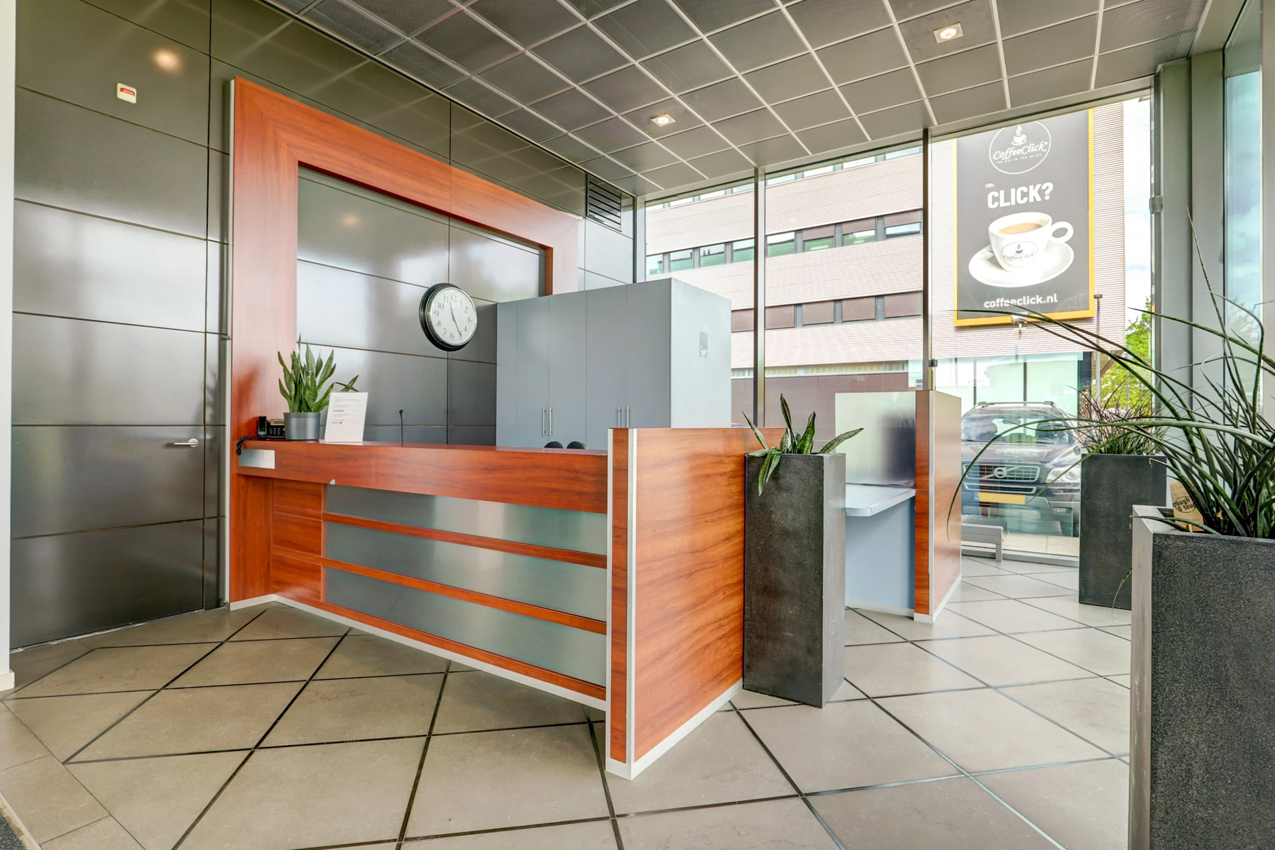 Moderne receptiebalie met houten en metalen accenten in een kantoorpand aan de New Yorkstraat.