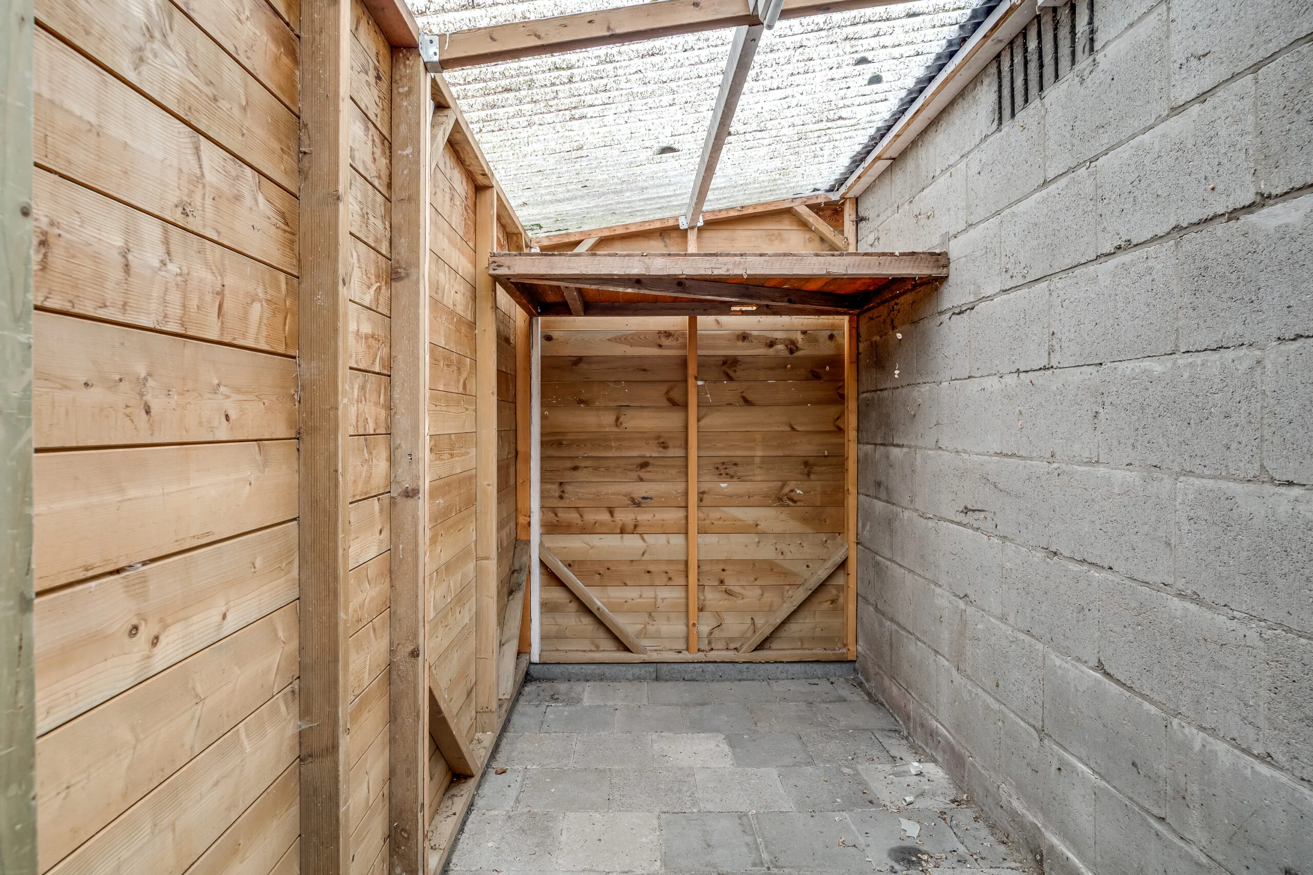 Overkapping met houten wanden en een transparant dak aan de Balderikstraat.