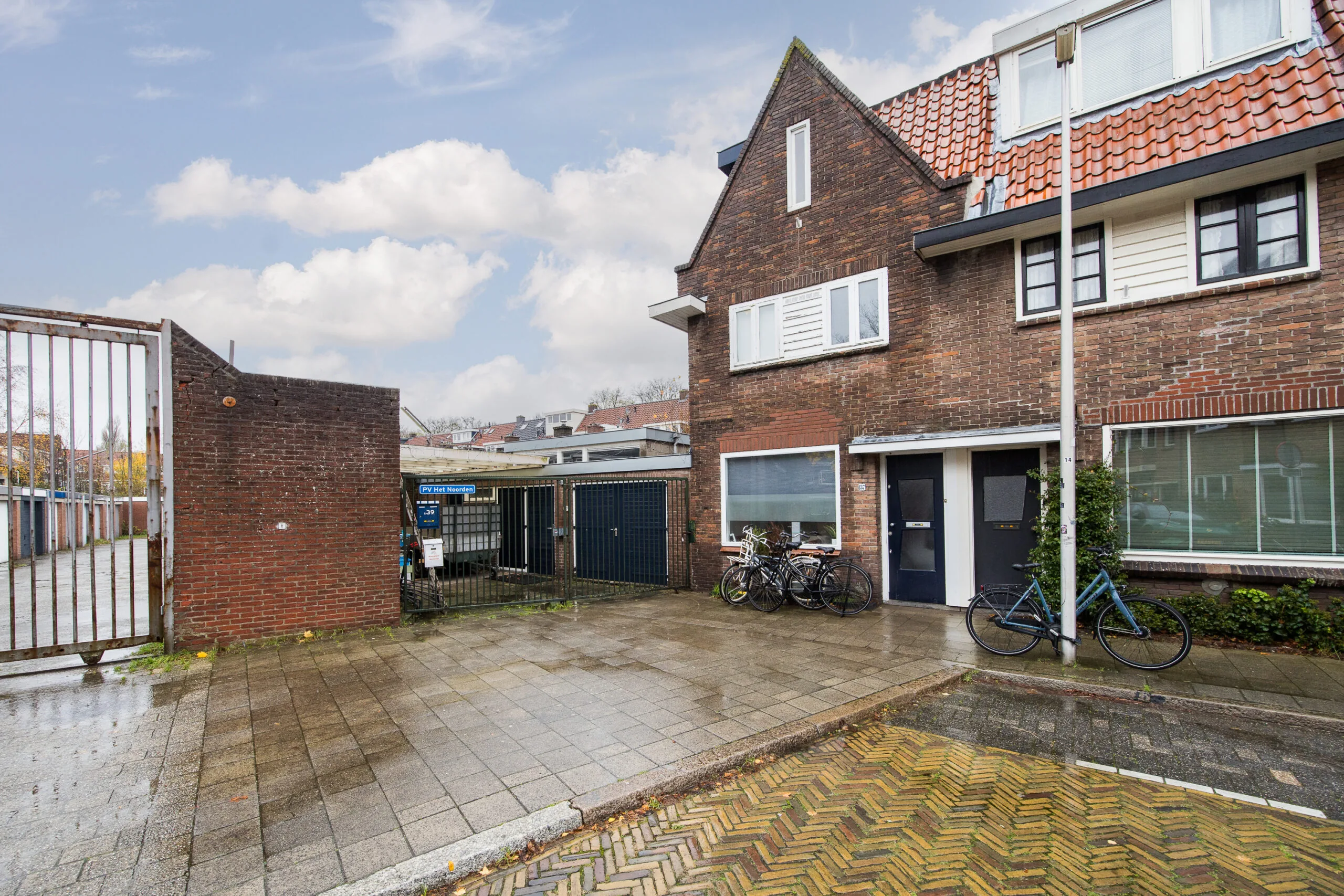 Vooraanzicht van een rijtjeshuis aan de Balderikstraat met fietsen voor de deur en een poort naar een binnenterrein.