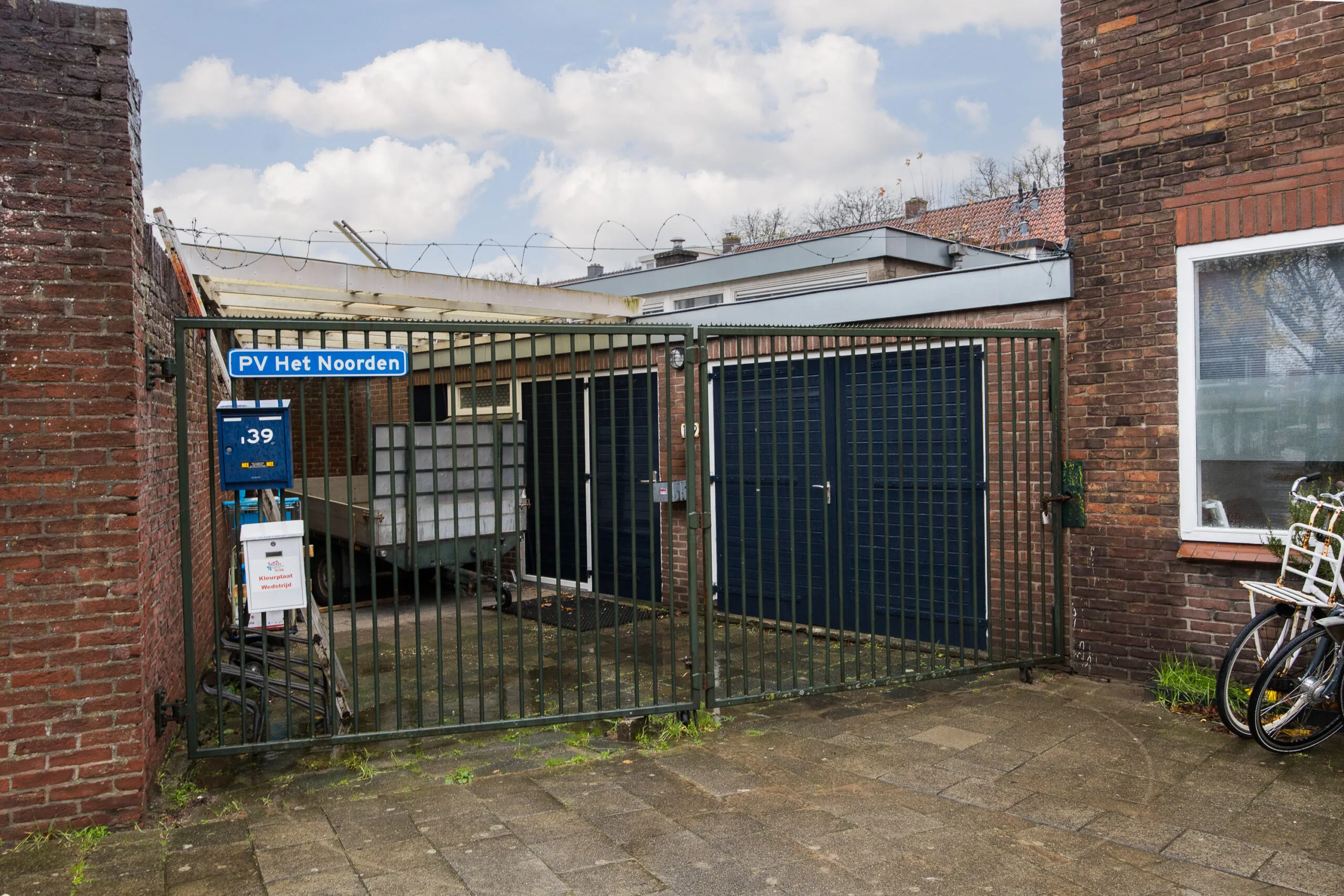 Grote metalen poort met het bord "PV Het Noorden" en huisnummer 39 aan de Balderikstraat.