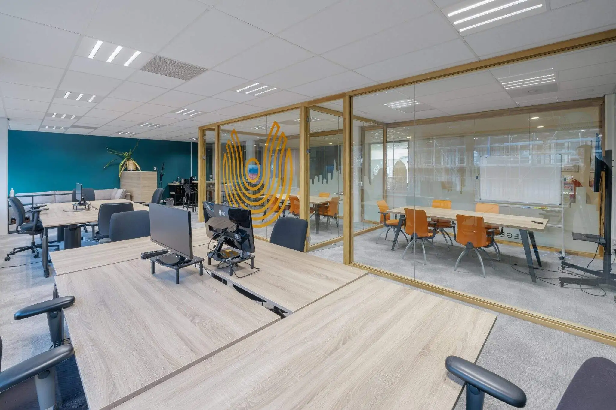 Een moderne kantoorruimte aan de Joan Muyskenweg met open werkplekken en een vergaderzaal met glazen wanden.