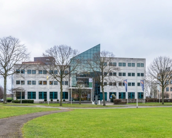 Kantoorgebouw aan de K.P. van der Mandelelaan in Rotterdam met een opvallende glazen gevel en omliggend groen.