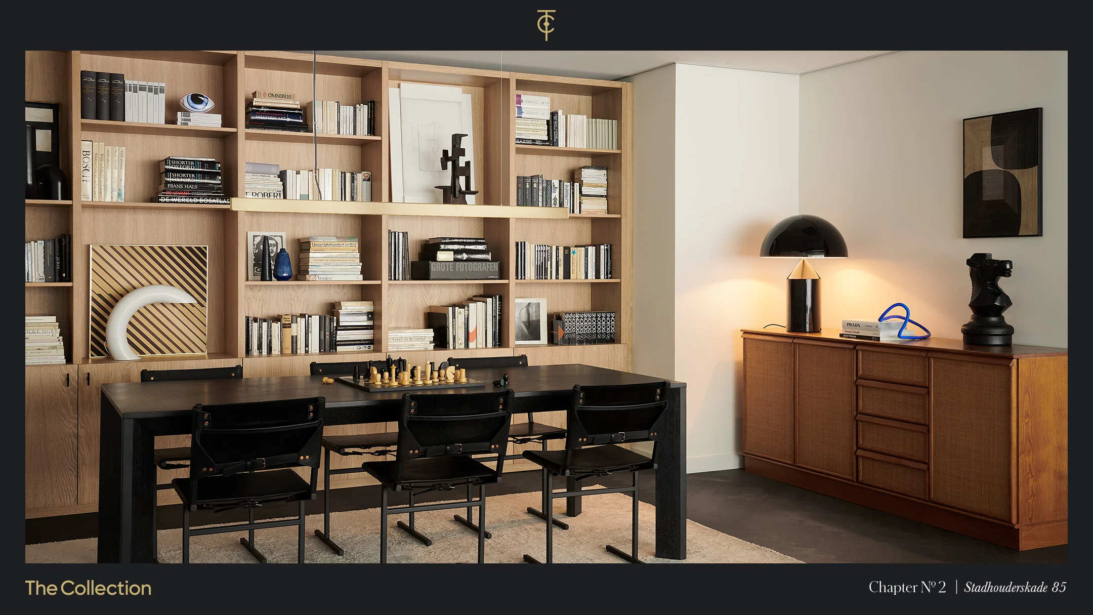 Stijlvol ingericht interieur aan de Stadhouderskade met een boekenwand, moderne kunstobjecten, een zwarte eettafel en een houten dressoir.