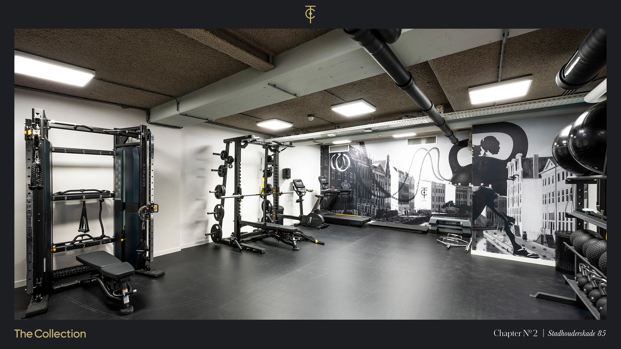 Moderne fitnessruimte aan de Stadhouderskade 85 met kracht- en cardioapparatuur en een muurschildering van Amsterdamse grachtenpanden.
