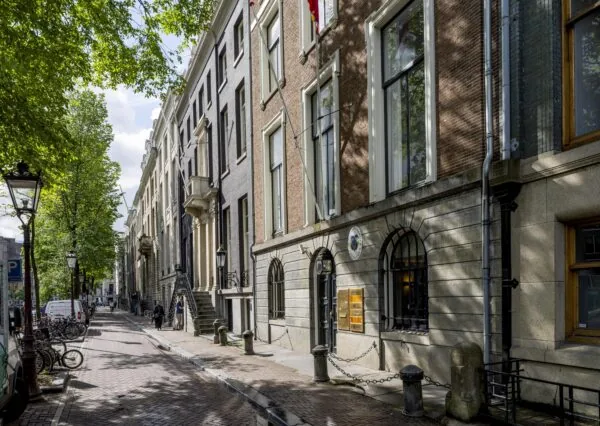 Gevels van herenhuizen aan de Herengracht in Amsterdam op een zonnige dag.