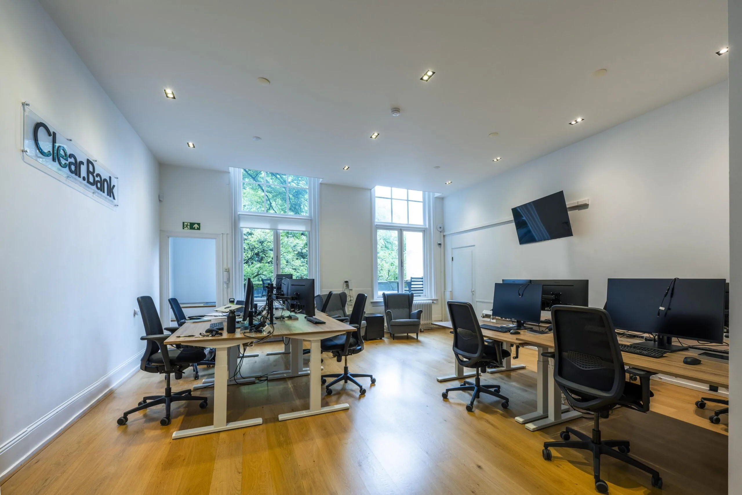 Modern kantoorinterieur van ClearBank aan de Herengracht met bureaus, computers en grote ramen.