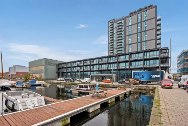 Modern kantoorgebouw aan de Saturnusstraat met uitzicht op een jachthaven en aanlegsteiger.