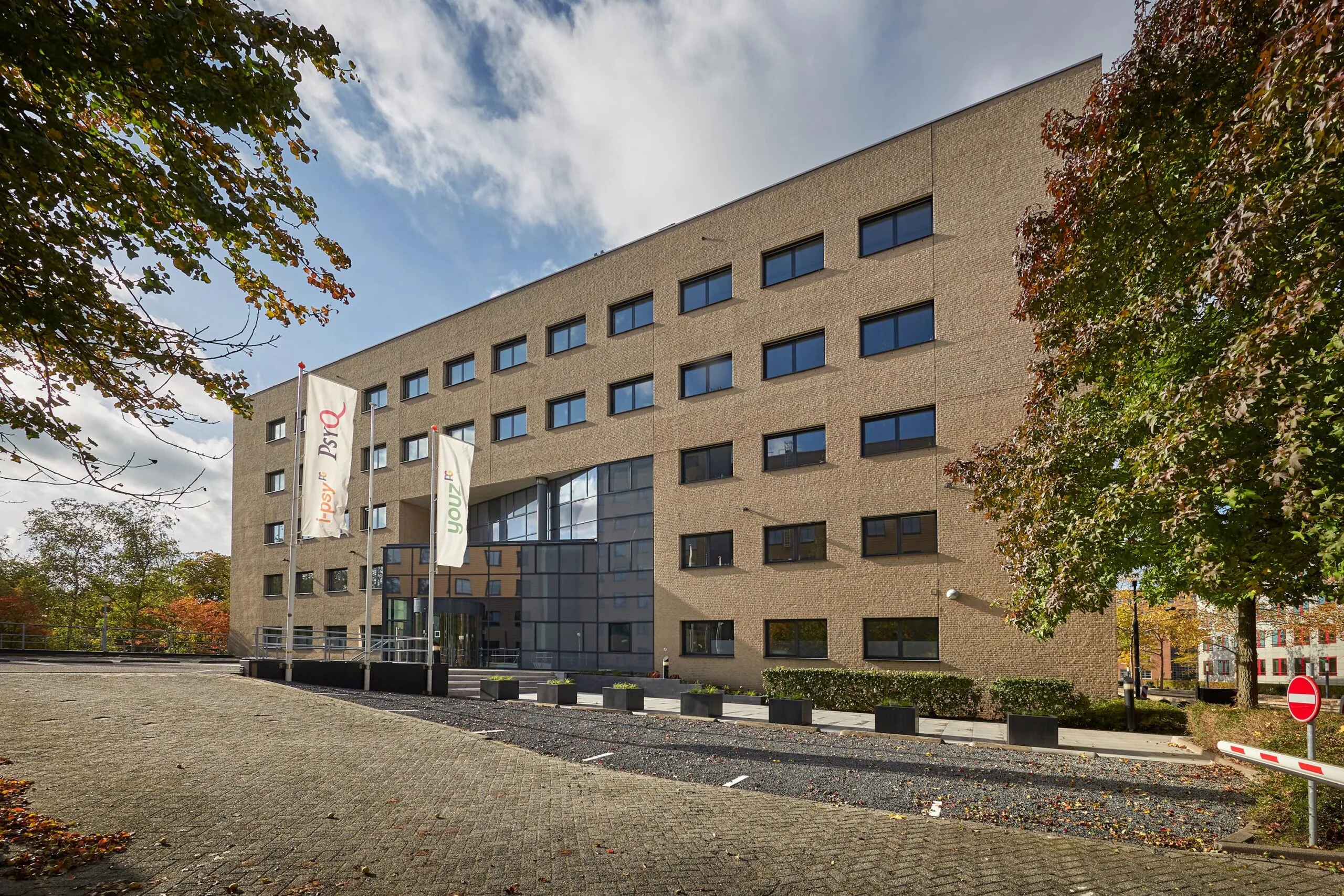 Vooraanzicht van het kantoorgebouw aan de Euclideslaan met vlaggen van Youz en de Parnassia Groep.