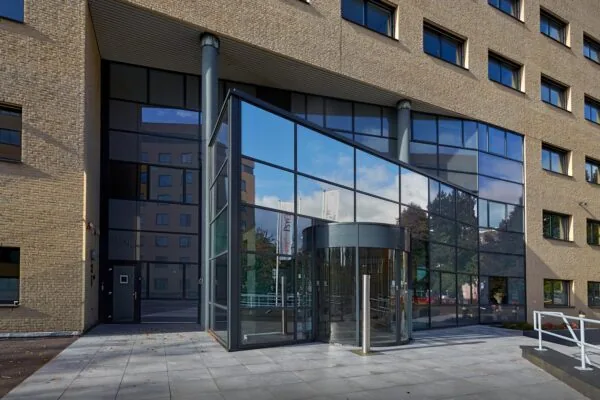 Moderne glazen entree met draaideur van een kantoorgebouw aan de Euclideslaan.