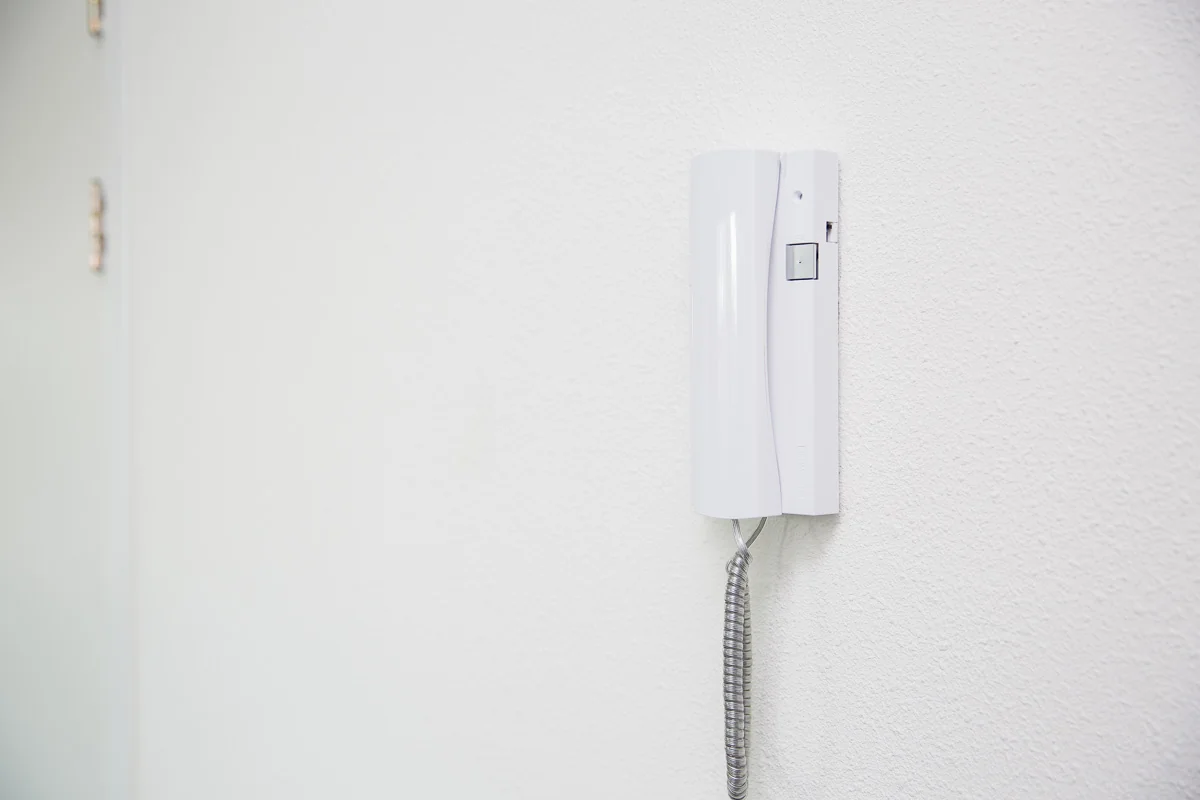 Witte intercom aan een witte muur in een gang van een gebouw aan de Laan van ’s-Gravenmade.