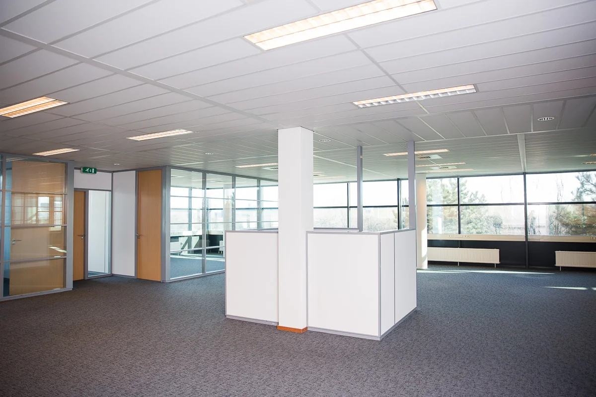 Moderne, lege kantoorruimte aan de Laan van s-Gravenmade met glazen wanden en systeemplafond.