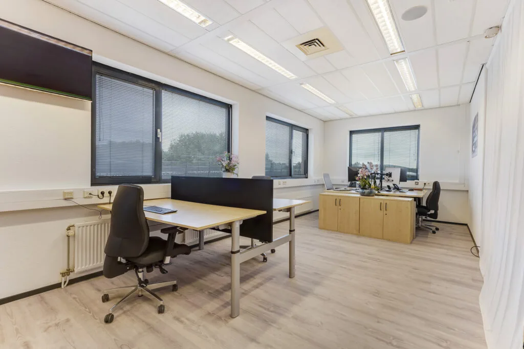 Modern kantoor aan de Laan van s-Gravenmade met meerdere werkplekken, grote ramen en lichte houten vloer.