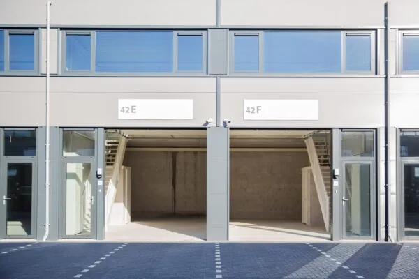 Twee lege bedrijfsunits met glazen deuren en binnenliggende trappen aan de Laan van ‘s-Gravenmade, genummerd 42E en 42F.