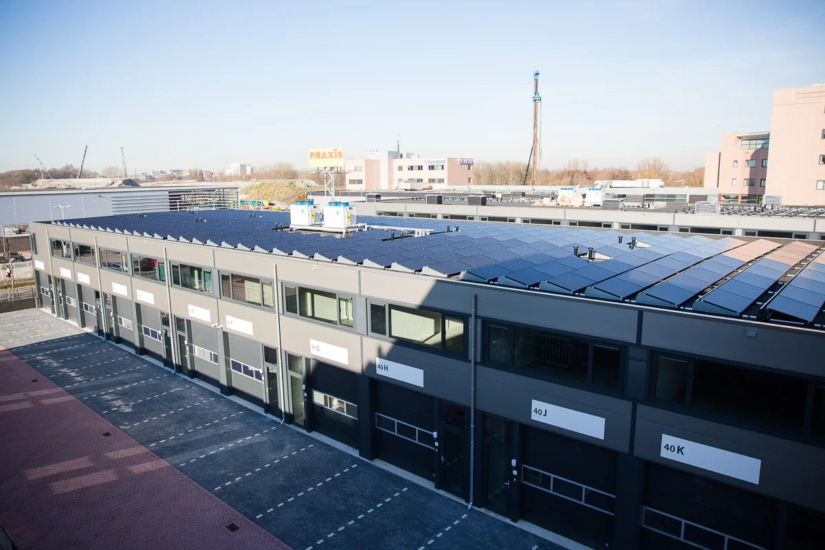 Bedrijfsverzamelgebouw aan de Laan van ’s-Gravenmade met zonnepanelen op het dak en zicht op de Praxis in de achtergrond.