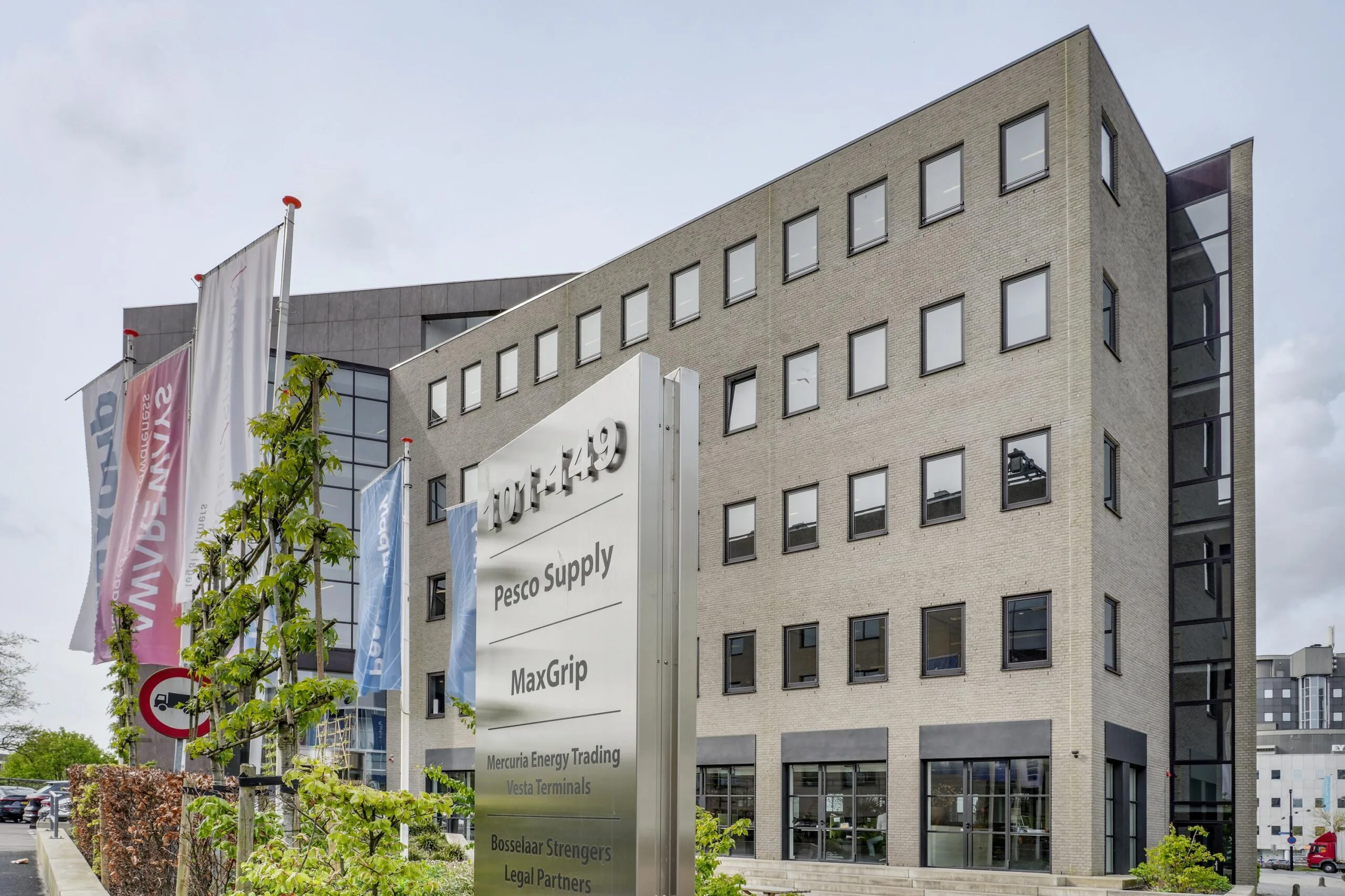 Kantoorgebouw aan de Euclideslaan met bedrijfsnamen op een groot gevelbord en vlaggenmast op de voorgrond.