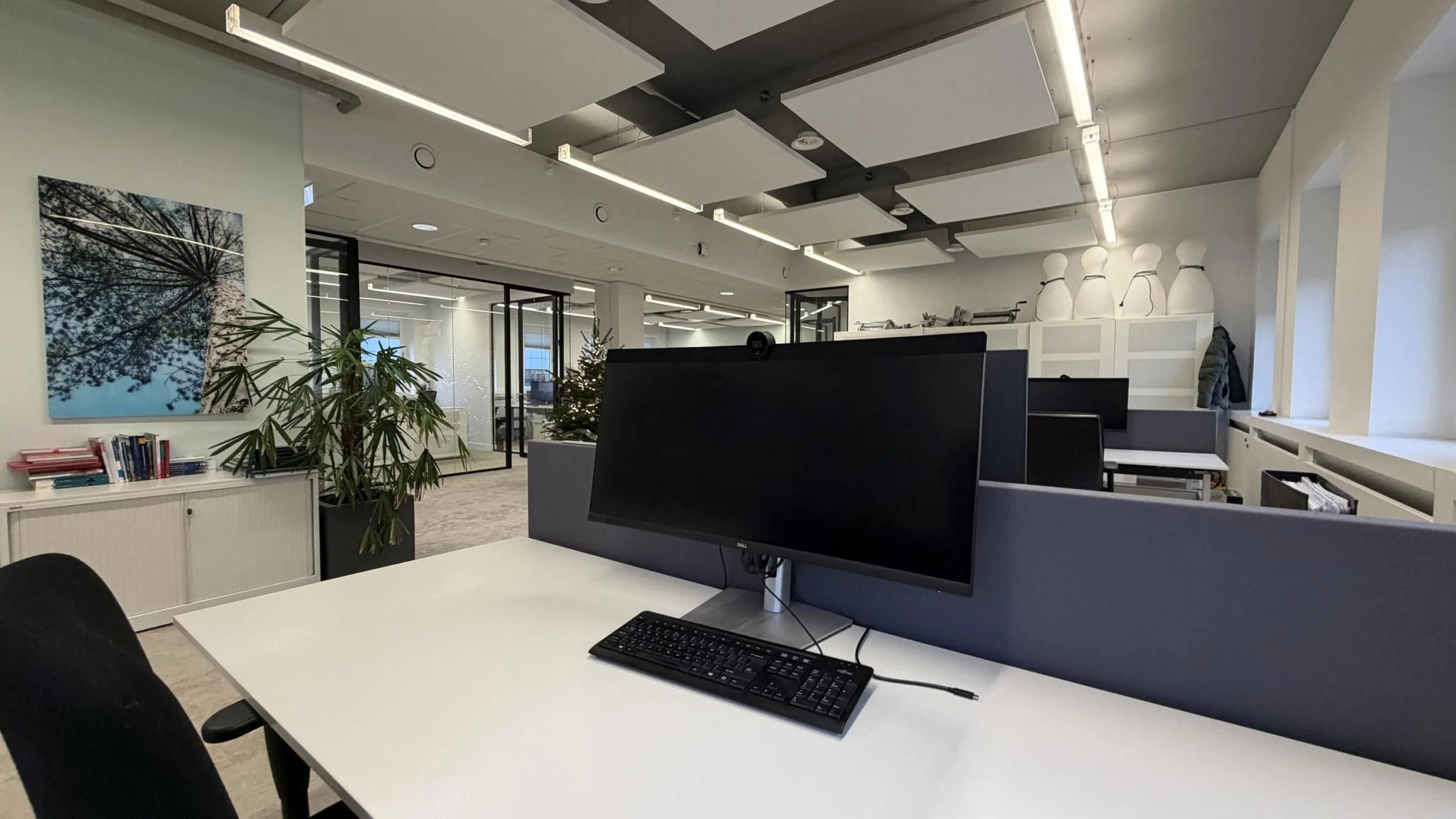 Moderne open kantoorruimte aan de Euclideslaan met werkplekken, planten en glazen wanden.