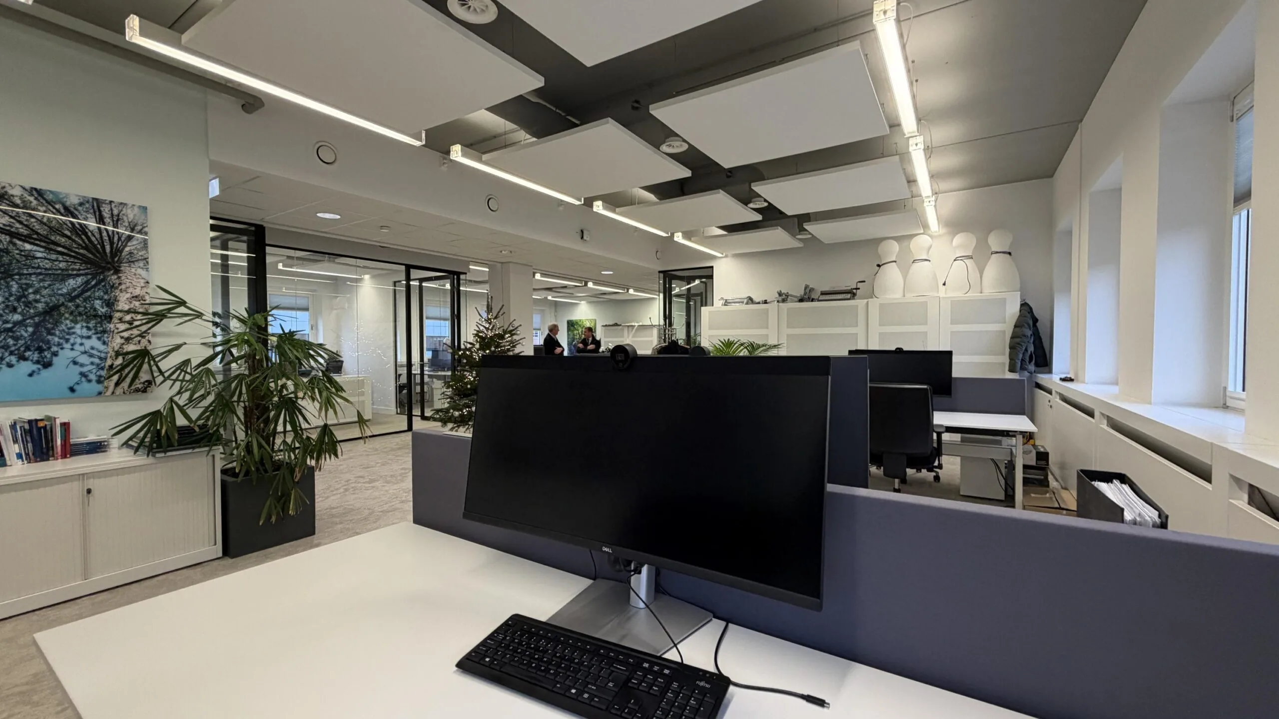 Modern kantoorinterieur aan de Euclideslaan met werkplekken, planten en glazen vergaderruimtes.