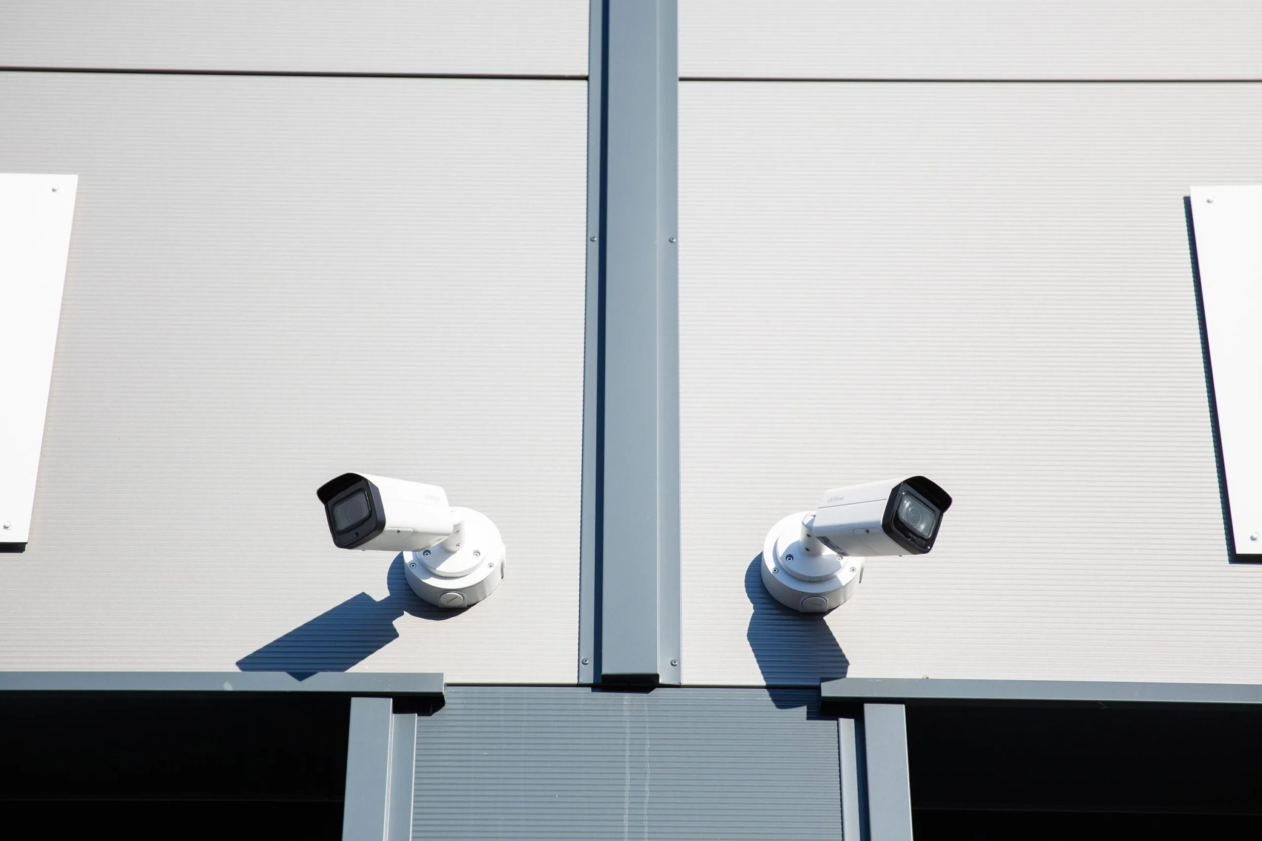 Twee beveiligingscamera's bevestigd aan de gevel van een modern bedrijfsgebouw aan de Laan van ’s-Gravenmade.