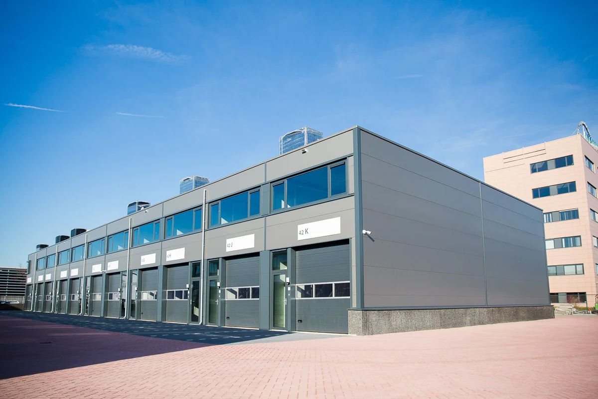 Modern bedrijfspand aan de Laan van ‘s-Gravenmade met meerdere bedrijfsunits onder een blauwe lucht.