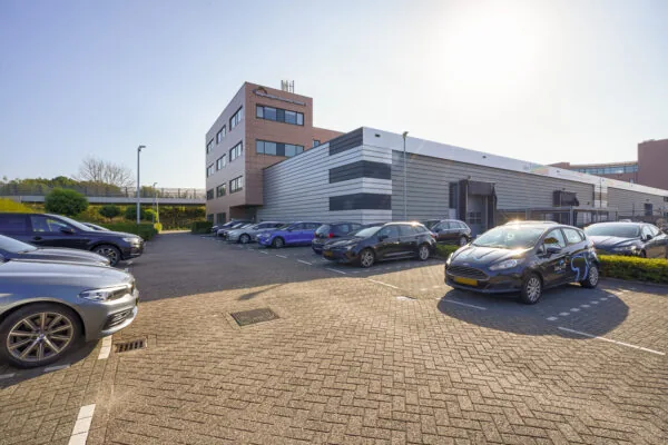 Parkeerterrein met geparkeerde auto's voor het Regenbogen Business Center aan de Laan van s-Gravenmade.