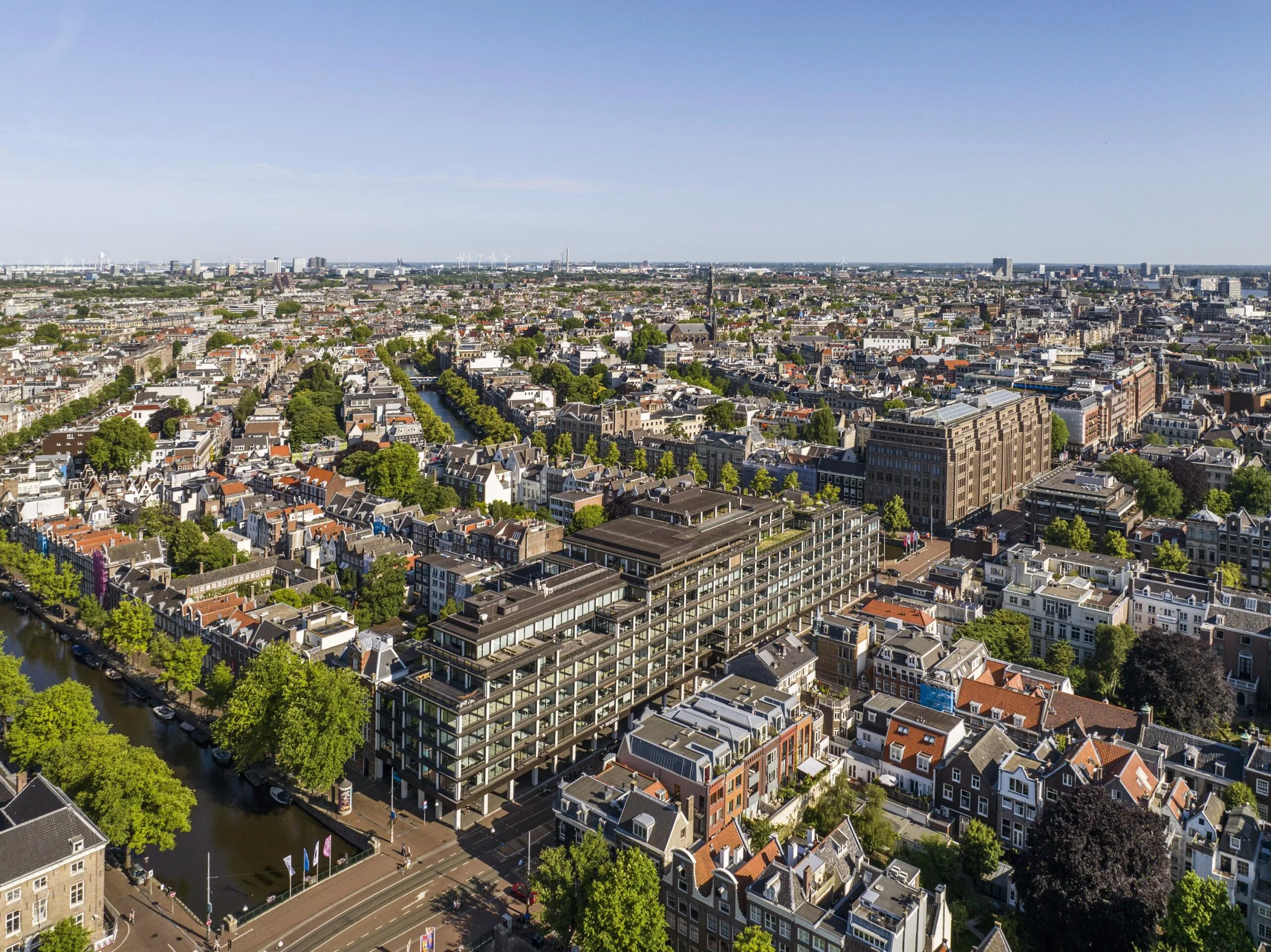 Luchtfoto van de Vijzelstraat in Amsterdam met uitzicht op het moderne gebouw De Nederlandsche Bank en omliggende grachtenpanden.