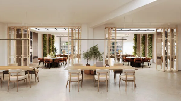 Modern en licht interieur van een kantoorruimte aan de Baarsjesweg met houten meubels, groene plantenwanden en vergadertafels.