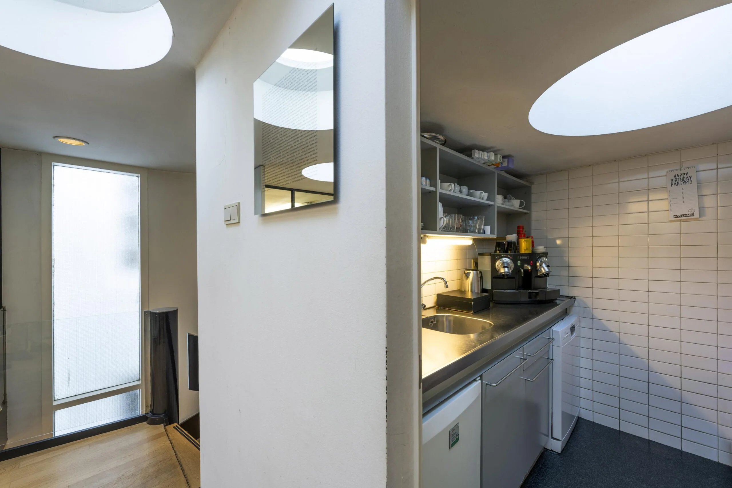 Kleine pantry met koffiezetapparaat en open planken, gelegen aan de Herengracht.