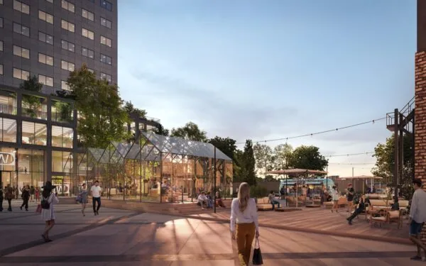 Modern stadsplein aan de Basisweg met een glazen kas, zitgelegenheden en mensen die ontspannen in de avondzon.