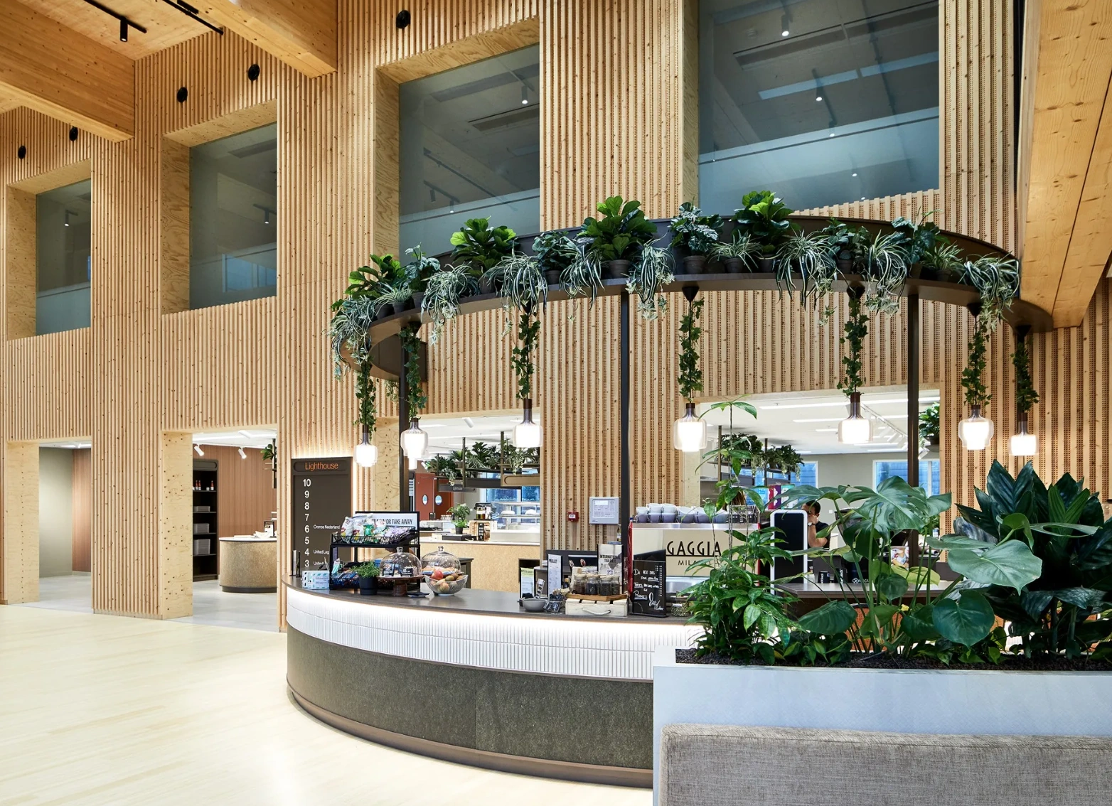 Moderne, open koffiebar met veel groen in het Lighthouse-gebouw aan de Basisweg.