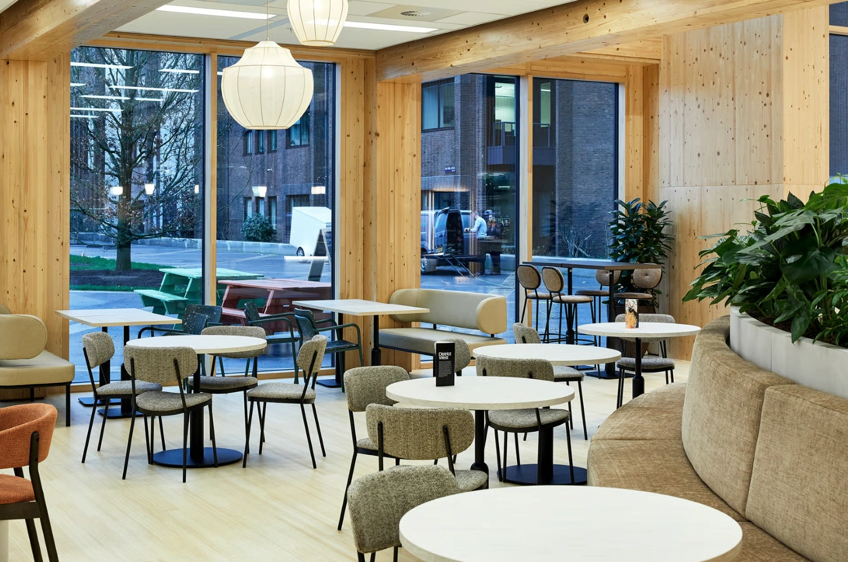 Moderne en lichte zithoek met houten accenten in een bedrijfsrestaurant aan de Basisweg.