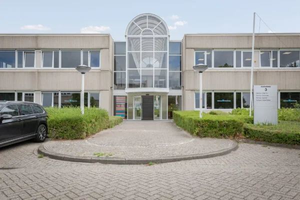Vooraanzicht van een kantoorgebouw aan de Energieweg 3 met een moderne entree en omliggende beplanting.