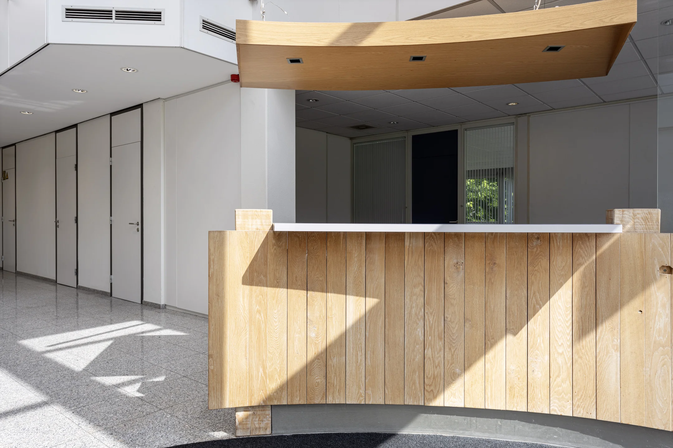 Receptiebalie van hout in een lichte, moderne kantoorruimte aan de Energieweg.