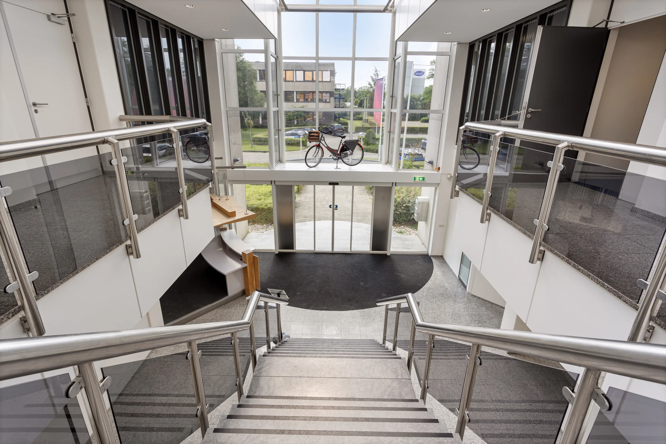 Moderne entreehal van een kantoorpand aan de Energieweg met een fiets voor een grote glazen pui.