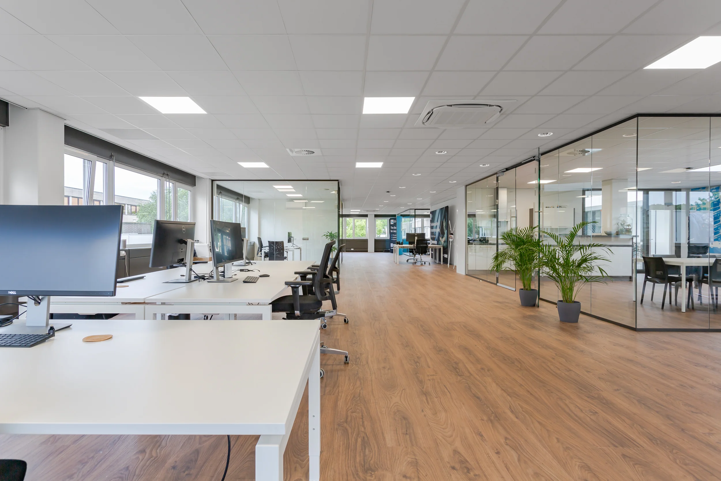 Modern en licht kantoorinterieur aan de Energieweg met glazen vergaderzalen en werkplekken.